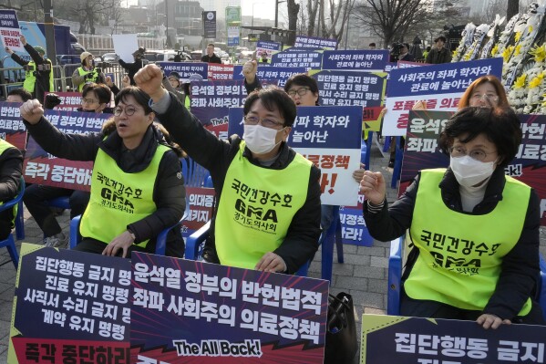 Members of the Gyeonggi Province Medical Association stage a rally against the government's medical policy near the presidential office in Seoul, South Korea, Wednesday, March 13, 2024. South Korea's government criticized senior doctors at a major hospital Tuesday for threatening to resign in support of the weekslong walkouts by thousands of medical interns and residents that have disrupted hospital operations. The banners read "Stop President Yoon Suk Yeol government's medical policy." (AP Photo/Ahn Young-joon)