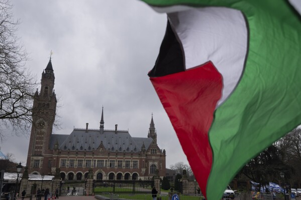 A Palestinian flag flies outside the United Nations' highest court, rear, during historic hearings in The Hague, Netherlands, Wednesday, Feb. 21, 2024, into the legality of Israel's 57-year occupation of the West Bank and east Jerusalem, plunging the 15 international judges back into the heart of the decades-long Israeli-Palestinian conflict. Six days of hearings at the International Court of Justice, during which an unprecedented number of countries will participate in proceedings, are scheduled as Israel continues its devastating assault on Gaza. (AP Photo/Peter Dejong)