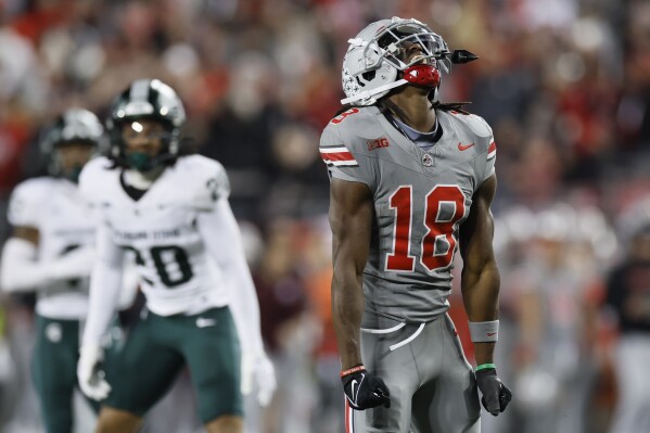 Ohio State receiver Marvin Harrison, right, celebrates a reception for a first down against Michigan State during the second half of an NCAA college football game Saturday, Nov. 11, 2023, in Columbus, Ohio. (AP Photo/Jay LaPrete)