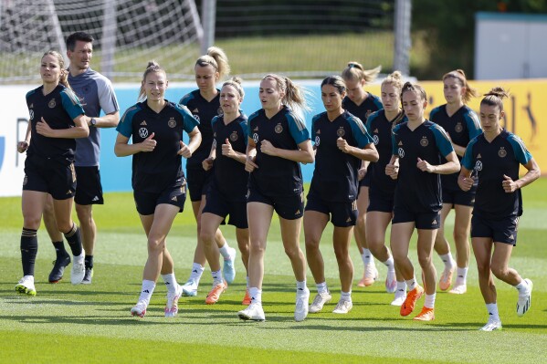 From left, players Melanie Leupholz, Sarai Linder, Lena Lattwein, Svenja Hut, Laura Freigang, Sara Doorsoun, Carolin Simon, Sophia Kleinherne, Chantal Hagel and Felicitas Rauch warm up during training session of the German women's national soccer team in Herzogenaurach, Germany, Monday, June 3, 2023. The women's soccer world championships take place in Australia and New Zealand from July 20, 2023 until August 20, 2023. (Daniel Loeb/dpa/dpa via AP)