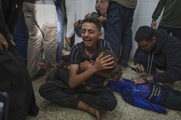 Mohammed Abed, center, weeps as he holds the body of his younger sister, Massa , 4, who was killed in an Israeli army airstrike on the Gaza Strip, at the morgue of Al-Aqsa Hospital in Deir al-Balah, Gaza, Sunday, April 27, 2025. (AP Photo/Abdel Kareem Hana, File)