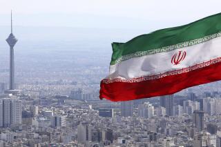 FILE - In this March 31, 2020, file photo, Iran's national flag waves as Milad telecommunications tower and buildings are seen in Tehran, Iran. A British-Australian academic serving a 10-year sentence for espionage in Iran has been moved to a notorious prison where concerns for her well-being have escalated, the Australian government confirmed Wednesday. (AP Photo/Vahid Salemi, File)