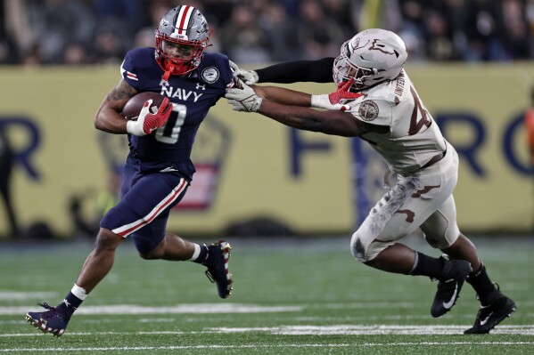 FILE - Navy fullback Chance Warren (0) runs against Army during the second half of an NCAA college football game Dec. 11, 2021, in East Rutherford, N.J. Army and Navy will line up their triple-option offenses on Saturday, Dec. 9, 2023, at the home of the New England Patriots for a day full of pageantry, tradition and a deeply rooted respect that comes with one of college football's fiercest rivalries. (APPhoto/Adam Hunger, File)