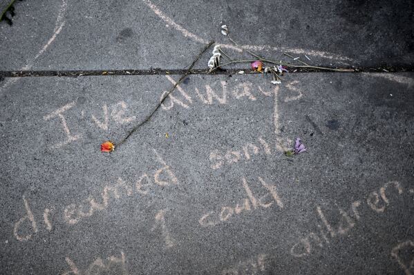 A wilted rose lays on a sidewalk outside the downtown Metropolitan Detention Center Tuesday, June 17, 2025, in Los Angeles. (AP Photo/Wally Skalij)