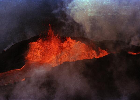 FILE - Molten rock flows from Mauna Loa on March 28, 1984, near Hilo, Hawaii. Hawaii officials are warning residents of the Big Island to prepare for the possibility that the world's largest active volcano may erupt given a recent spike in earthquakes at the summit of Mauna Loa. Scientists don't expect the volcano to erupt imminently, but officials are reminding people lava could reach some homes in just a few hours when it does. (AP Photo/Ken Love, File)