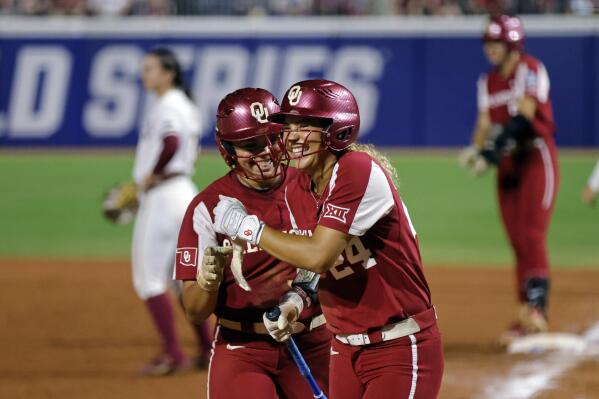 Oklahoma's Alyssa Brito, left, and Jayda Coleman celebrate after Coleman scored against Florida State during the fifth inning of the first game of the NCAA Women's College World Series softball championship series Wednesday, June 7, 2023, in Oklahoma City. (AP Photo/Nate Billings)