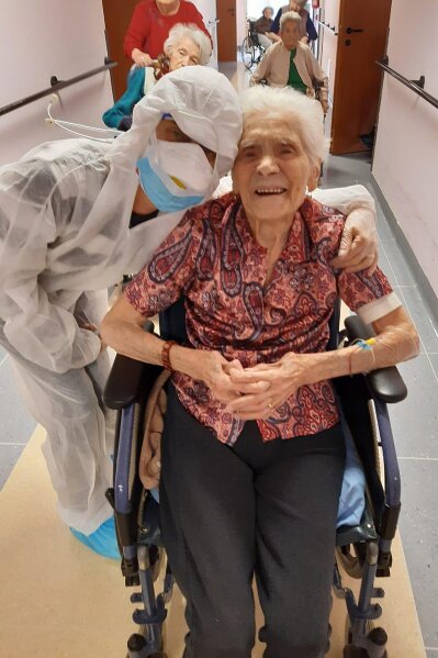 In this photo taken on April 1, 2020, 103-year-old Ada Zanusso, poses with a nurse at the old people's home "Maria Grazia" in Lessona, northern Italy, after recovering from Covid-19 infection. To recover from coronavirus infection, as she did, Zanusso recommends courage and faith, the same qualities that have served her well in her nearly 104 years on Earth.The new coronavirus causes mild or moderate symptoms for most people, but for some, especially older adults and people with existing health problems, it can cause more severe illness or death. (Residenza Maria Grazia Lessona via AP Photo)
