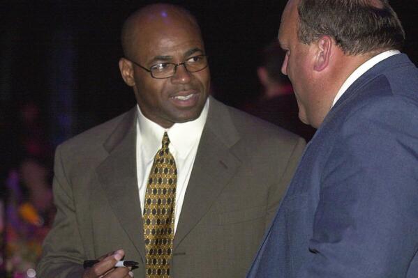 FILE - In this Tuesday, June 26, 2001, file photo, former New Orleans Saints player Sam Mills, left, signs an autograph for Gene Ponti of Monroe, La., during the 2001 Louisiana Sports Hall of Fame Induction banquet at the Horseshoe Casino in Bossier City, La. The New Orleans Saints will soon add the name of the late Sam Mills to their ring of honor in the Superdome. The club announced the decision to honor Mills, who died from cancer in 2005, during halftime of their Dec. 2 home game against Dallas. (Matthew Minard/The Shreveport Times via AP, File)