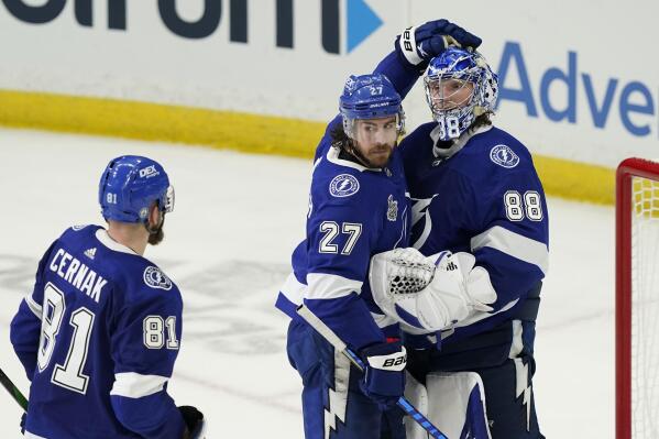 Tampa Bay Lightning defenseman Ryan McDonagh (27) pats goaltender Andrei Vasilevskiy's helmet after the third period in Game 1 of the NHL hockey Stanley Cup finals against the Montreal Canadiens, Monday, June 28, 2021, in Tampa, Fla. (AP Photo/Gerry Broome)