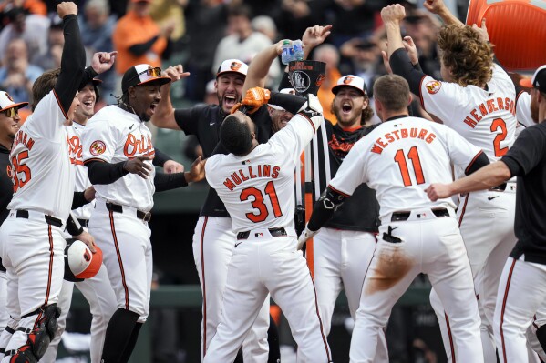Baltimore Orioles' Cedric Mullins drinks from the "Homer Hydration Station" as he celebrates with teammates after hitting a walk-off home run against the Minnesota Twins in the ninth inning of a baseball game, Wednesday, April 17, 2024, in Baltimore. The Orioles won 4-2. (AP Photo/Jess Rapfogel)