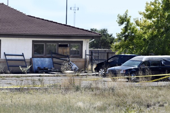 FILE - A hearse and debris can be seen at the rear of the Return to Nature Funeral Home in Penrose, Colo., Oct. 5, 2023. A family filed a lawsuit Monday, Oct. 30, against the Colorado funeral home where 189 decaying bodies were found alleging that the owners, a husband and wife, allowed the remains of their loved ones and to “rot” away while they sent families fake ashes. (Jerilee Bennett/The Gazette via AP, File)
