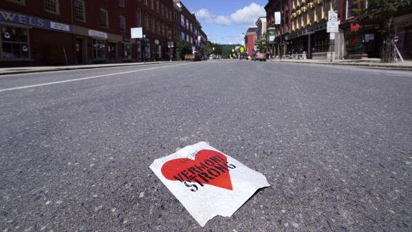 A "Vermont Strong" heart sign rests in the middle of State Street during the late morning on Tuesday, Aug. 1, 2023, in Montpelier, Vt. The mostly gutted shops, restaurants and businesses that lend downtown Montpelier its charm are considering where and how to rebuild in an era when extreme weather is occurring more often. Vermont's flooding was just one of several major flood events around the globe this summer that scientists have said are becoming more likely due to climate change. (AP Photo/Charles Krupa)