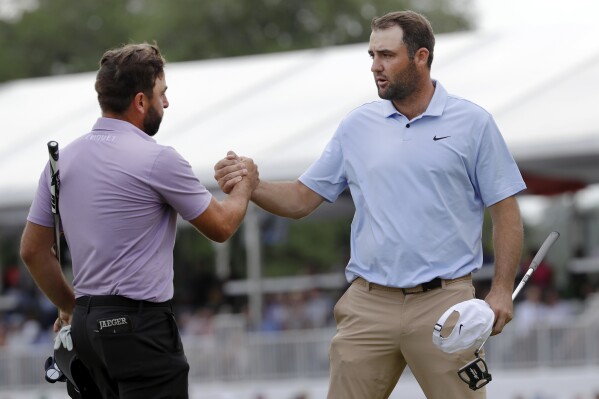 Stephan Jaeger, left, and Scottie Scheffler shake hands after finishing their round on the 18th green during the final round of the Houston Open golf tournament Sunday, March 31, 2024, in Houston.(AP Photo/Michael Wyke)