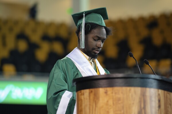 In this photo provided by Kewe Ukpolo, Elijah Hogan speaks during his graduation ceremony at Walter L. Cohen charter high school in New Orleans, Friday, May 24, 2024. Hogan graduated as one of two valedictorians at the charter high school. (Kewe Ukpolo via AP)
