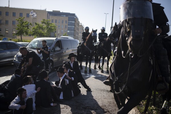Israeli police officers disperse ultra-Orthodox Jewish men and boys during a protest against army recruitment in Jerusalem, Sunday, June 2, 2024. Israel's Supreme Court is hearing the cases against the military enlistment exemptions of ultra-Orthodox Jewish men as the Israeli military's manpower has been strained by the nearly eight-month-long war against Hamas in Gaza. Its decision is expected in the coming weeks. (AP Photo/Leo Correa)