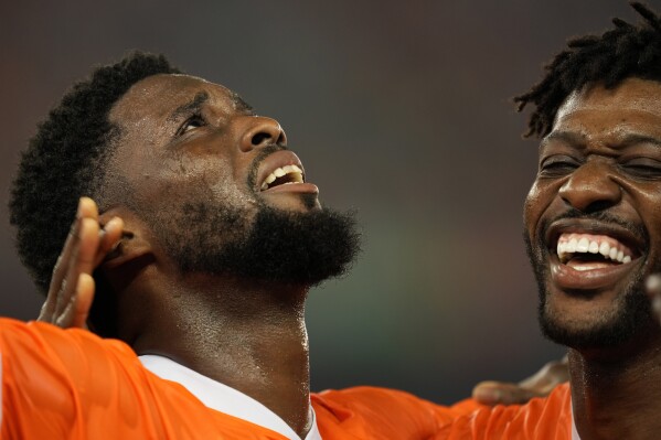 Ivory Coast's Jean-Philippe Krasso, left, celebrates with teammate after scoring his team second goal during the African Cup of Nations Group A soccer match between Ivory Coast and Guinea-Bissau in Abidjan, Ivory Coast, Saturday, Jan. 13, 2024. (AP Photo/Sunday Alamba)