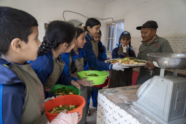 Students receive food from a zoo keeper to feed animals at Nepal’s Central Zoo in Lalitpur, Nepal, on Feb. 23, 2024. (AP Photo/Niranjan Shrestha)