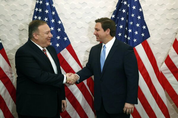 FILE - In this Jan. 23, 2020, file photo, Secretary of State Mike Pompeo, left, and Florida Gov. Ron DeSantis pose for a photo before participating in a roundtable discussion with Venezuelan exiles...