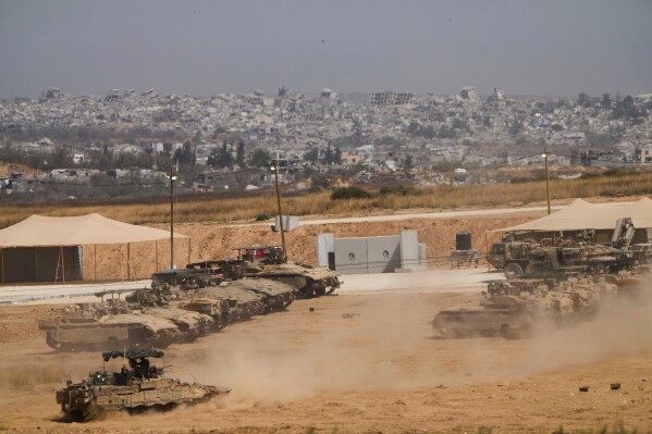 Israeli soldiers work on tanks and armored vehicles at a staging area near the border with the Gaza Strip, in southern Israel, Monday, May 26, 2025. (AP Photo/Ariel Schalit)