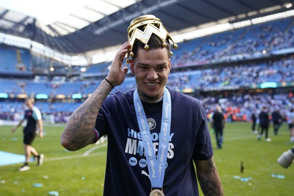 Manchester City's goalkeeper Ederson celebrates with the Premier League trophy after the English Premier League soccer match between Manchester City and West Ham United at the Etihad Stadium in Manchester, England, Sunday, May 19, 2024. Manchester City clinched the English Premier League on Sunday after beating West Ham in their last match of the season. (AP Photo/Dave Thompson)