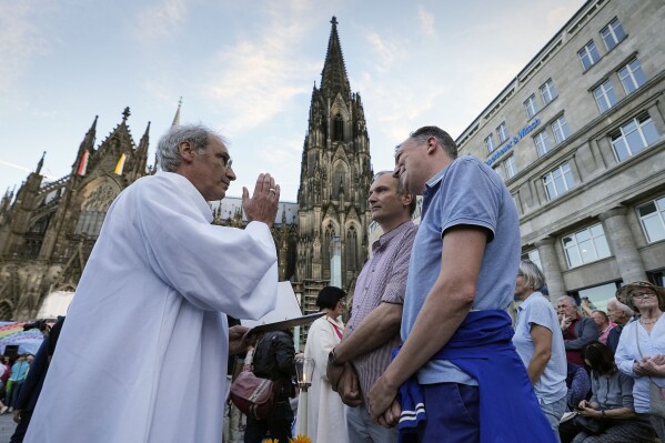 FILE - Same-sex couples take part in a public blessing ceremony in front of the Cologne Cathedral in Cologne, Germany, on Sept. 20, 2023. Pope Francis formally approved allowing priests to bless same-sex couples, with a new document released Monday Dec. 18, 2023 explaining a radical change in Vatican policy by insisting that people seeking God's love and mercy shouldn't be subject to "an exhaustive moral analysis" to receive it. (AP Photo/Martin Meissner, File)