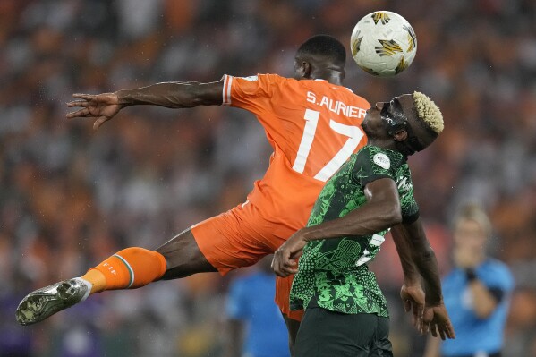 Nigeria's Victor Osimhen, right, is challenged by Ivory Coast 's Serge Aurier during the African Cup of Nations final soccer match between Ivory Coast and Nigeria, at the Olympic Stadium of Ebimpe in Abidjan, Ivory Coast, Sunday, Feb. 11, 2024. (APPhoto/Themba Hadebe)