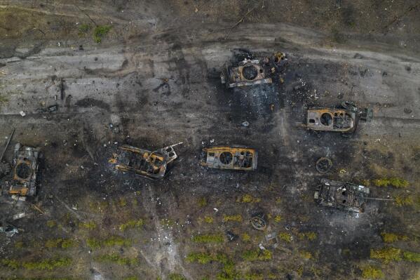 FILE - Destroyed Russian armored vehicles sit on the outskirts of Kyiv, Ukraine, March 31, 2022. In the year since Russia invaded Ukraine, disinformation and propaganda have emerged as key weapons in the Kremlin's arsenal. (AP Photo/Rodrigo Abd, File)