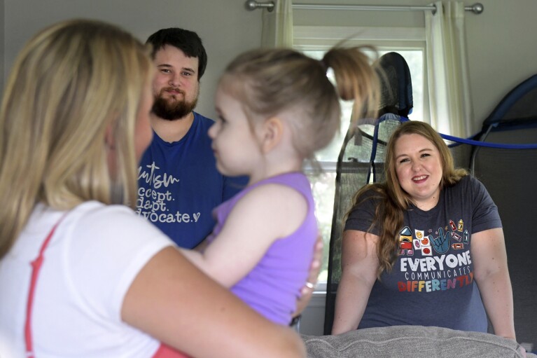 Early Intervention speech pathologist Megan Sanders works with 2-year-old Aria Faulkner as parents Lindsey and Kendrick Faulkner look on during a therapy session at the Faulkner's home in Peoria, Ill., Aug. 15, 2023. (AP Photo/Ron Johnson)