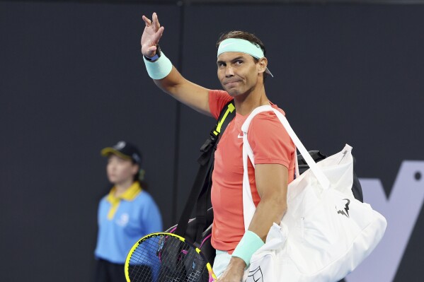 FILE - Rafael Nadal, of Spain, waves to the crowd at his doubles match against Australia's Max Purcell and Jordan Thompson during the Brisbane International tennis tournament in Brisbane, Australia, Dec. 31, 2023. Nadal played an unofficial event Sunday, March 3, 2024, losing to fellow Spaniard Carlos Alcaraz 3-6, 6-4 (14-12) in The Netflix Slam in Las Vegas. (AP Photo/Tertius Pickard, File)