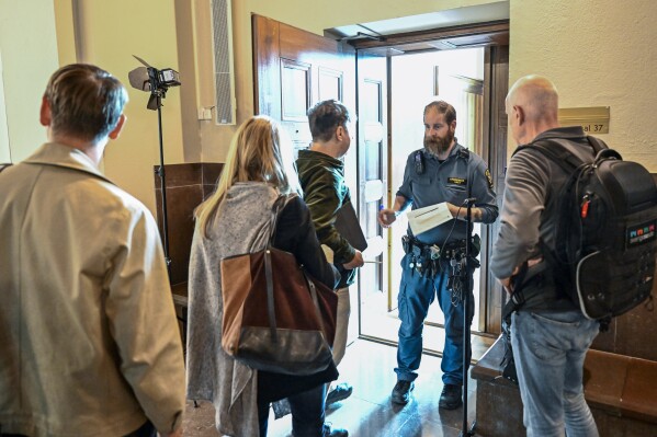 FILE - People wait outside a courtroom at the Stockholm District Court for the trial of a Russian-born Swedish citizen charged with collecting information for the Russian military intelligence service GRU for almost a decade, in Stockholm, on Sept. 4, 2023. A Swedish court on Monday, Oct. 9, 2023, released a Russia-born Swedish citizen charged with collecting information for the Russian military intelligence service GRU for almost a decade. Sergey Skvortsov, 60, is accused of “gross illegal intelligence activities against Sweden and against a foreign power,” namely the United States. Skvortsov, who is awaiting a verdict in his trial which ended Sept. 28, was released with the Stockholm District Court saying that “there is no longer reason to keep the defendant in custody.” The verdict is due Oct. 26. (Jonas Ekstromer/TT News Agency via AP)