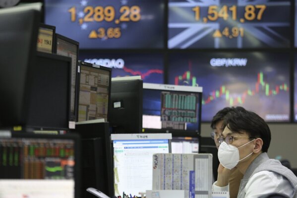 A currency trader wearing a face mask watches monitors at the foreign exchange dealing room of the KEB Hana Bank headquarters in Seoul, South Korea, Thursday, Feb. 20, 2020. Asian shares were mixed Thursday after Wall Street recovered to record highs, but worries continued about the damage to the regional economy from the new virus that began in China. (AP Photo/Ahn Young-joon)