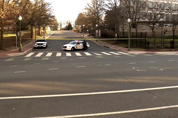 In this image taken from video, police are deployed outside the Israeli Embassy in Washington, Sunday, Feb. 25, 2024, after an active-duty member of the U.S. Air Force was critically injured after setting himself ablaze outside the diplomatic compound. (WJLA via AP)