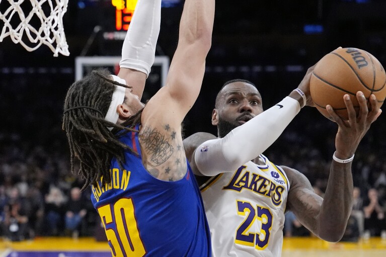 Los Angeles Lakers forward LeBron James, right, shoots as Denver Nuggets forward Aaron Gordon defends during the second half of an NBA basketball game Saturday, March 2, 2024, in Los Angeles. (AP Photo/Mark J. Terrill)