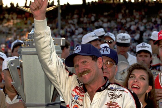 FILE - NASCAR driver Dale Earnhardt of Mooresville, N.C., gestures to the crowd from after winning the Brickyard 500 auto race at Indianapolis Motor Speedway, Saturday, Aug. 5, 1995. To mark NASCAR’s 75th season, The Associated Press interviewed 12 key contributors to the industry on multiple topics. According to the survey, Dale Earnhardt's death in the 2001 Daytona 500 was picked as NASCAR's most pivotal moment. (AP Photo/Tom Strattman, File)