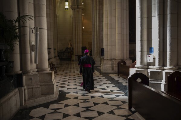 A bishop walks through an empty Almudena cathedral prior Easter Sunday Mass, in Madrid, Spain, Sunday, April 12, 2020. Pope Francis is calling for solidarity the world over to confront the "epochal challenge" posed by the coronavirus pandemic. The new coronavirus causes mild or moderate symptoms for most people, but for some, especially older adults and people with existing health problems, it can cause more severe illness or death. (AP Photo/Bernat Armangue)