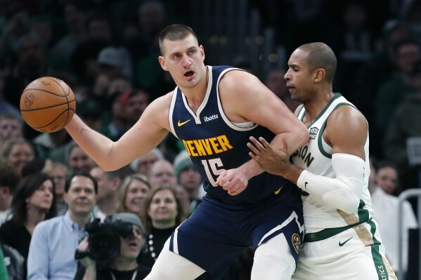 Denver Nuggets' Nikola Jokic (15) is defended by Boston Celtics' Al Horford during the first half of an NBA basketball game Friday, Jan 19, 2024, in Boston. (AP Photo/Michael Dwyer)