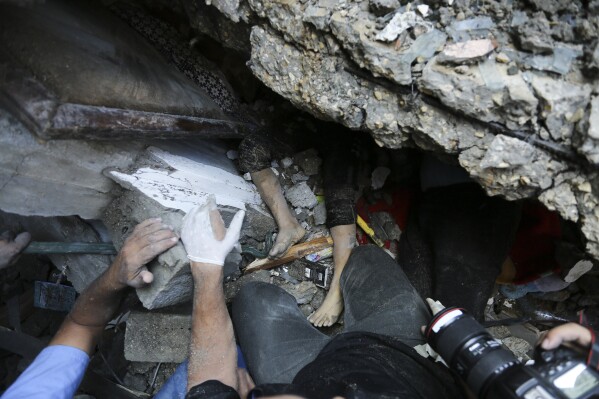 Palestinians try to rescue a child from under the rubble after Israeli airstrikes in Gaza City, Gaza Strip, Wednesday, Oct. 18, 2023. (AP Photo/Abed Khaled)