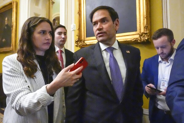 FILE - Sen. Marco Rubio, R-Fla., speaks with reporters as he walks, Feb. 28, 2024, at the Capitol in Washington. The Senate has advanced legislation that would reauthorize a key U.S. surveillance tool as lawmakers and the Biden administration rushed to tamp down fresh concerns about the program violating Americans' civil liberties. (AP Photo/Mark Schiefelbein, File)