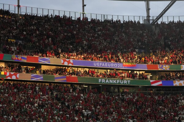 FILE - Supporters of Portugal wait for the start of a round of sixteen match between Portugal and Slovenia at the Euro 2024 soccer tournament in Frankfurt, Germany, Monday, July 1, 2024. Police in the German city of Frankfurt are investigating a video that appears to show a fan being punched and kicked while being detained by a group of Euro 2024 security personnel. (AP Photo/Matthias Schrader, File)