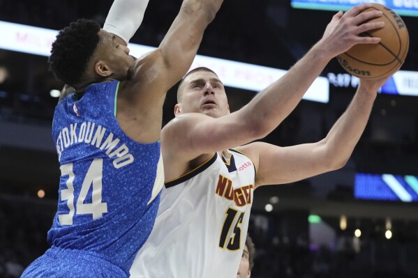 Denver Nuggets' Nikola Jokic tries to shoot past Milwaukee Bucks' Giannis Antetokounmpo during the first half of an NBA basketball game Monday, Feb. 12, 2024, in Milwaukee. (AP Photo/Morry Gash)