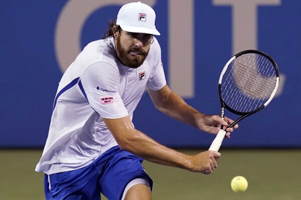 FILE - Reilly Opelka, of the United States, prepares to hit a backhand to Nick Kyrgios, of Australia, at the Citi Open tennis tournament in Washington, Thursday, Aug. 4, 2022. Reilly Opelka, of the United States, and Zhang Shuai, of China, have pulled out of the U.S. Open, the U.S. Tennis Association announced Tuesday, Aug. 15, 2023. (AP Photo/Carolyn Kaster, File)