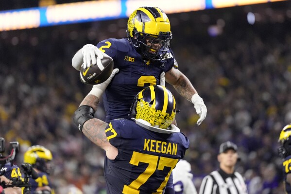 Michigan running back Blake Corum celebrates after scoring against Washington during the second half of the national championship NCAA College Football Playoff game Monday, Jan. 8, 2024, in Houston. (AP Photo/David J. Phillip)