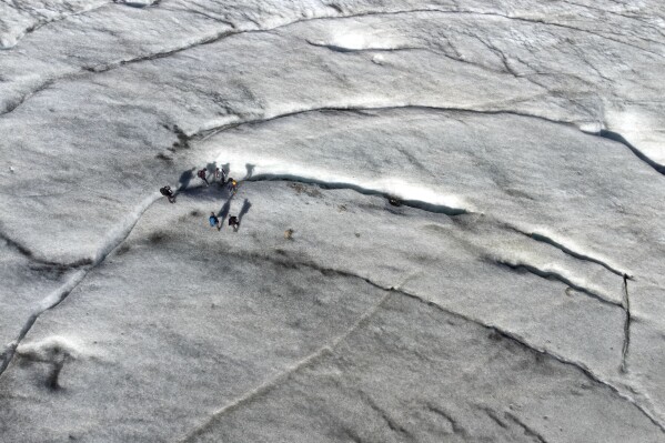 A group stands on the Jamtalferner Glacier near Galtuer, Austria, Wednesday, Sept. 6, 2023. (AP Photo/Matthias Schrader)