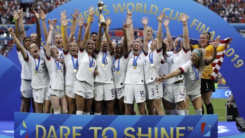 ARCHIVO - Las jugadores de Estados Unidos alzan el trofeo de campeones del mundo tras vencer a Holanda en la final de la Copa Mundial, el 7 de julio de 2019, en Decines, Francia. (AP Foto/Alessandra Tarantino)