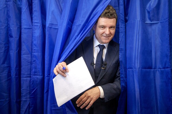 Presidential candidate Nicusor Dan exits a voting booth before casting his vote in the first round of the presidential election redo in Bucharest, Romania, Sunday, May 4, 2025. (AP Photo/Andreea Alexandru)