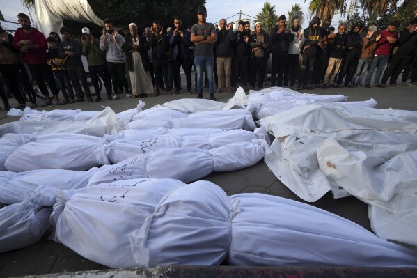 Palestinians mourn for their relatives killed in the Israeli bombing of the Gaza Strip, in front of the hospital morgue in Deir al Balah, Gaza Strip, Friday, Dec. 8, 2023.  (AP Photo/Adel Hana)