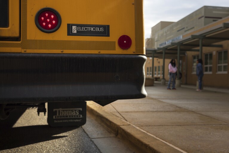 An electric school bus sits outside Rock Creek Forest Elementary School, Friday, Feb. 2, 2024, in Chevy Chase, Md. (AP Photo/Tom Brenner)