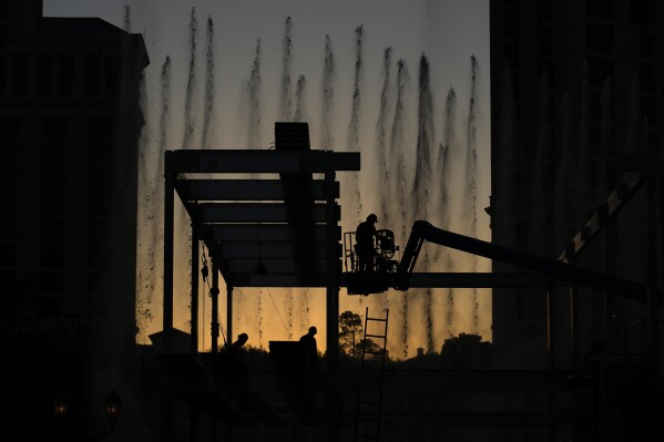 Construction workers build a grandstand in front of the fountains at Bellagio hotel-casino along the Las Vegas Strip ahead of the Las Vegas Formula One Grand Prix auto race Tuesday, Sept. 19, 2023, in Las Vegas. (AP Photo/John Locher)