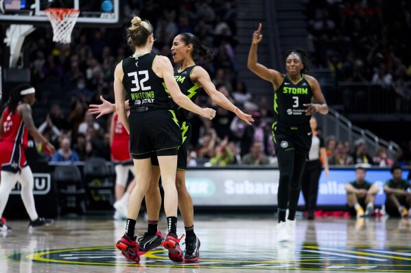 Seattle Storm guard Sami Whitcomb (32) celebrates with guard Skylar Diggins-Smith, second from left, after Diggins-Smith assisted forward Nneka Ogwumike (3) on a basket against the Washington Mystics during the second half of a WNBA basketball game Saturday, May 25, 2024, in Seattle. The Storm won 101-69. (AP Photo/Lindsey Wasson)