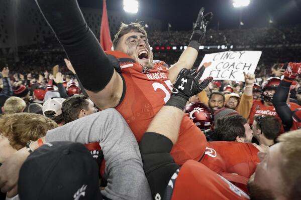 Cincinnati's Ryan Royer, center, celebrates with fans after winning the American Athletic Conference championship NCAA college football game against Houston Saturday, Dec. 4, 2021, in Cincinnati. (AP Photo/Jeff Dean)